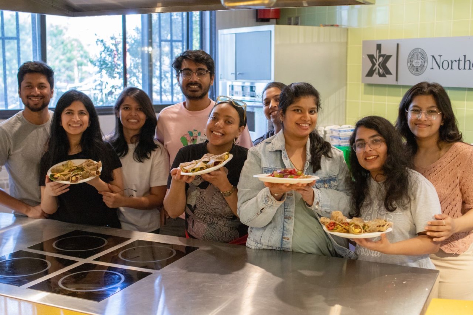 Friends holding plates of food they cooked together