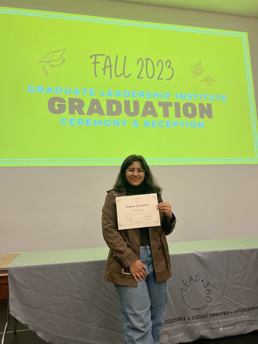 Pinkle holding a certificate at the Fall 2023 Graduate Leadership Institute graduation